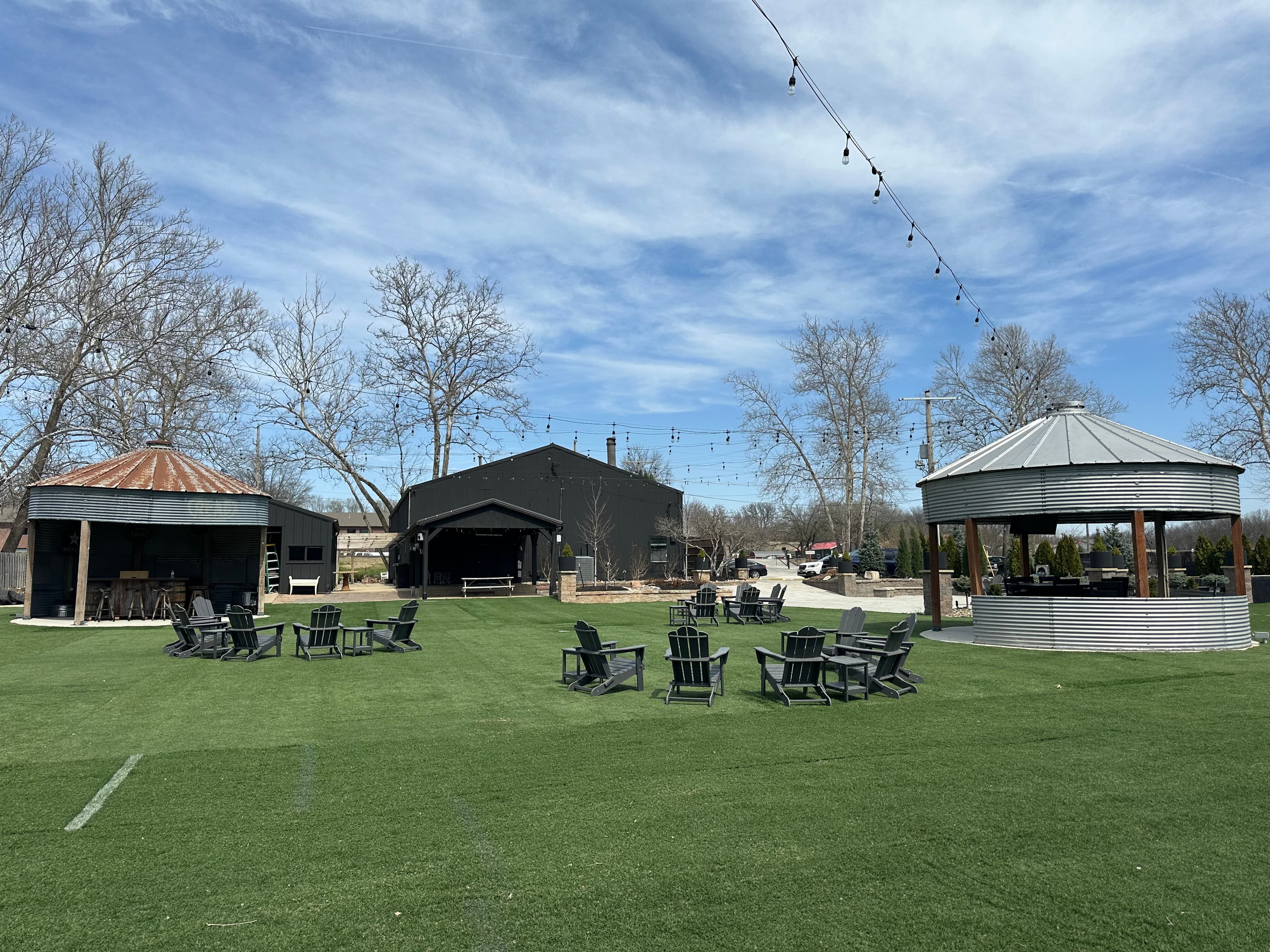 Venue lawn with main building, bar structures, and adirondack chairs